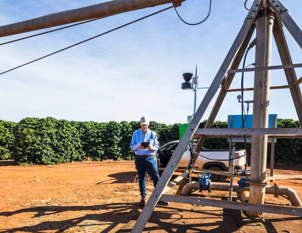 Hombre supervisando el sistema de riego desde su tableta para un uso eficiente del agua en la agricultura. Nombre: hombre-gestionando-sistema-de-riego-en-cultivo