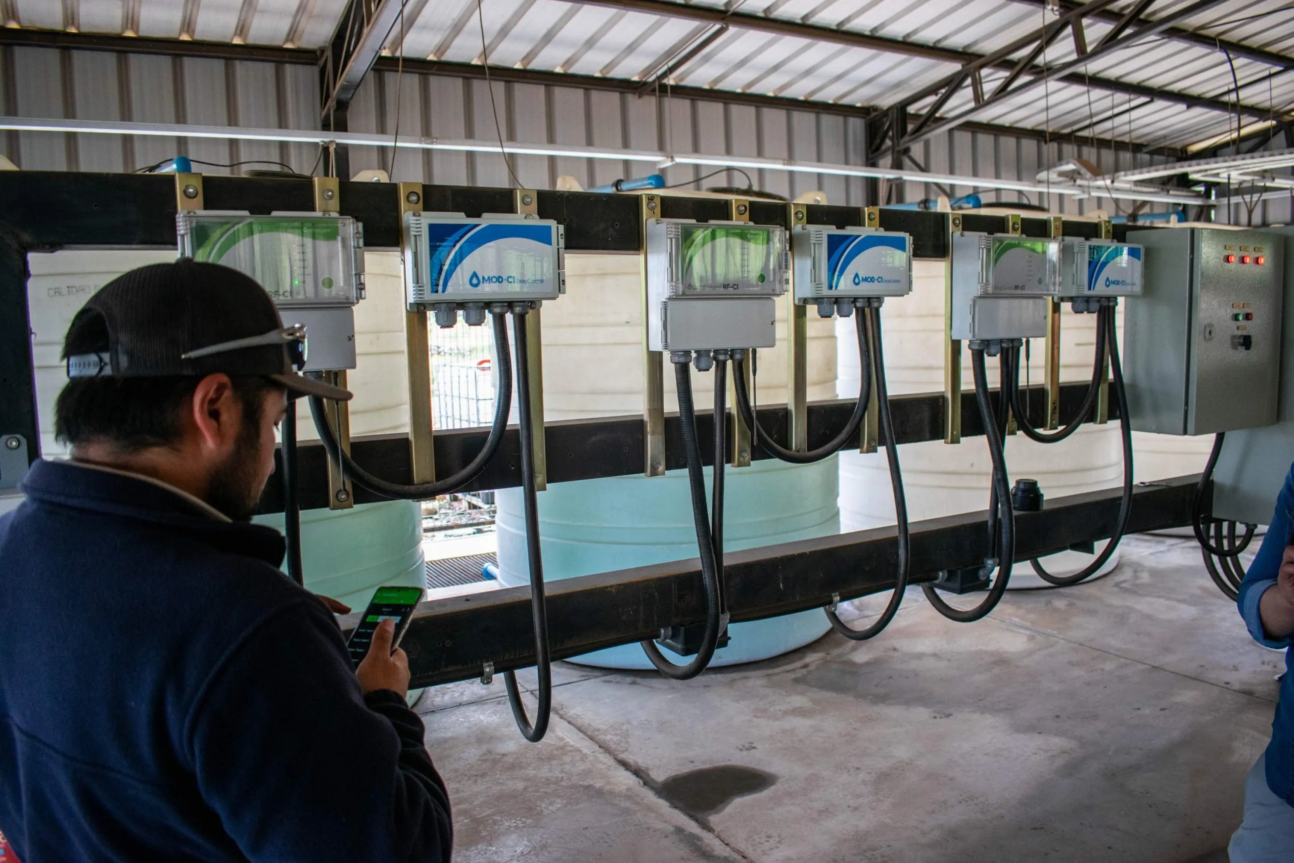 Infraestructura con bombas y contenedores de agua, optimizando la distribución mediante DROP CONTROL y software de control de riego