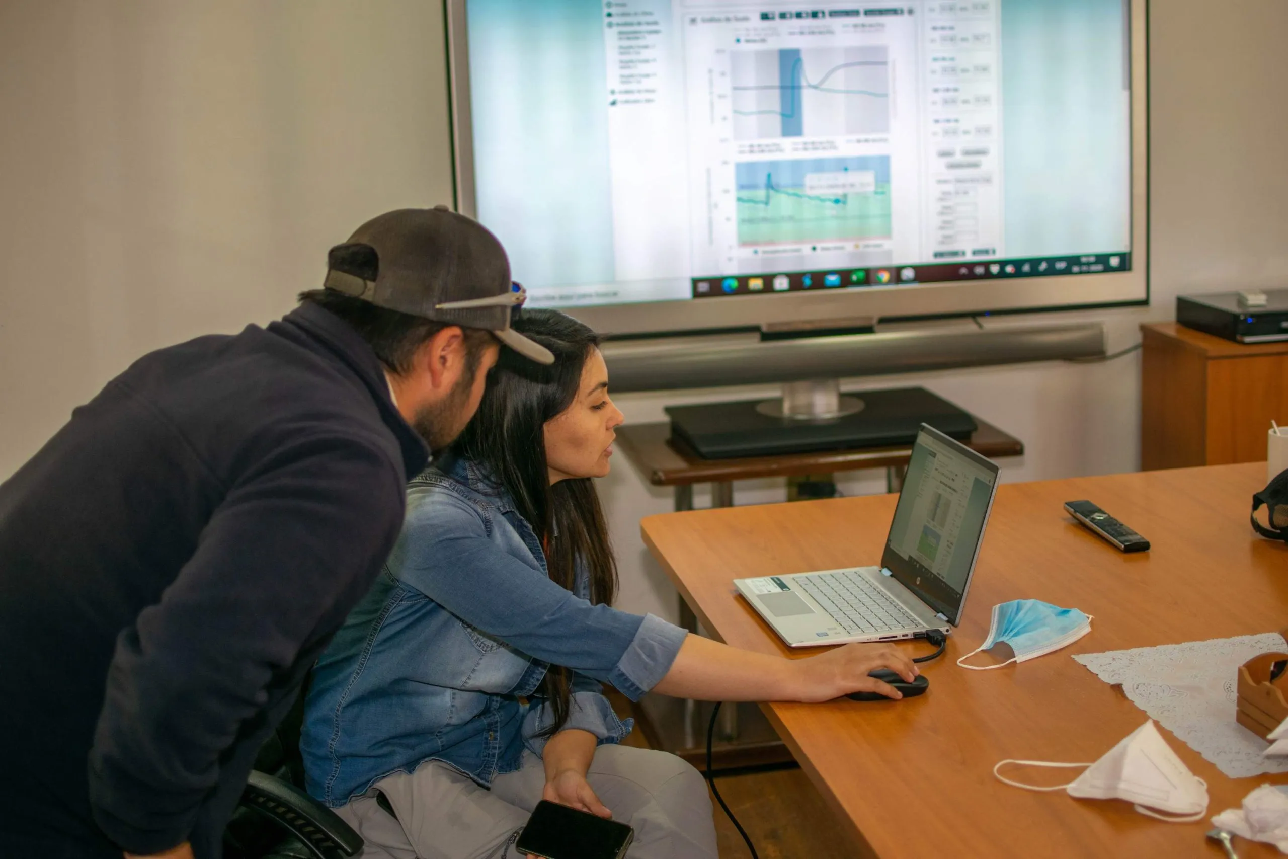 Professionals analyzing DROP CONTROL data from an office, integrating digital monitoring with farm automation solutions